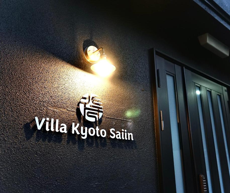 a sign on the side of a building with a light at Villa Kyoto Saiin in Kyoto