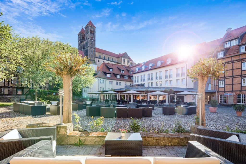 a courtyard with tables and trees and buildings at Best Western Hotel Schlossmühle Quedlinburg in Quedlinburg