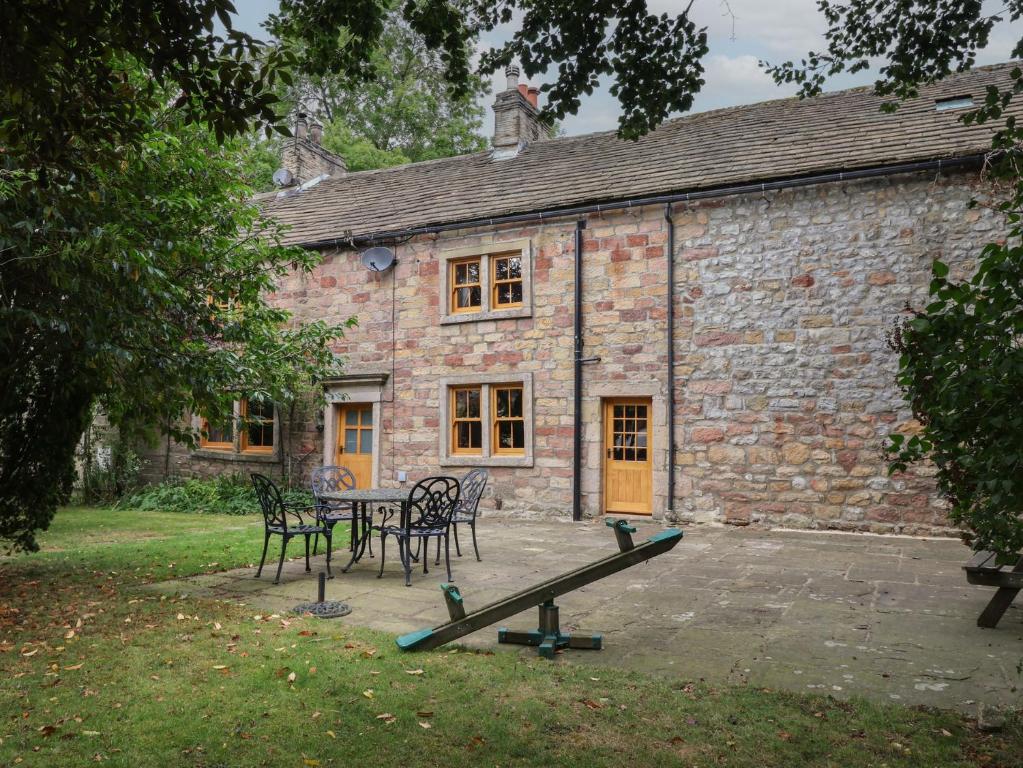 a table and chairs in front of a brick building at Bay Horse Farm in Skipton