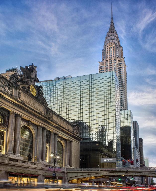 a building with a clock tower in front of a city at Hyatt Grand Central New York in New York