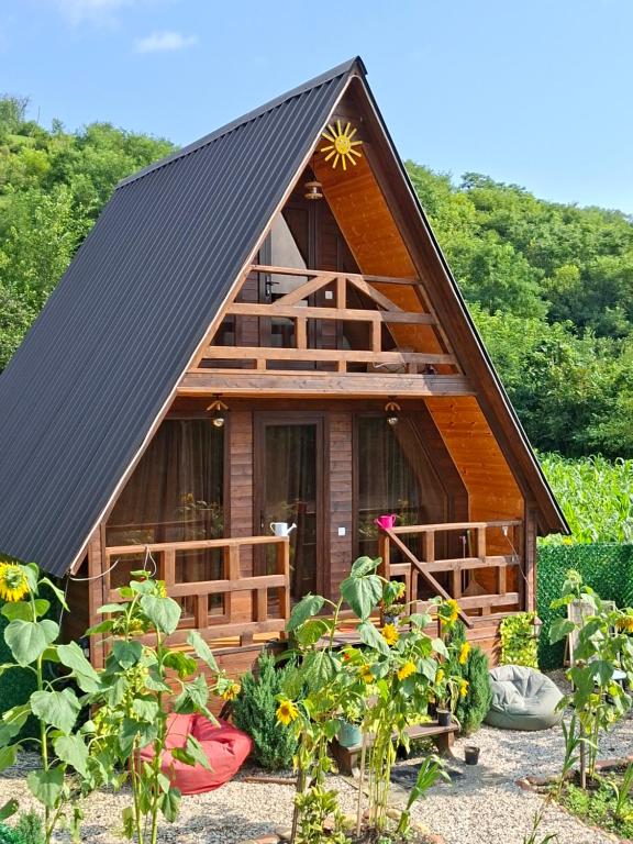 a small house with a black roof and some plants at WILD NEST Cottage 