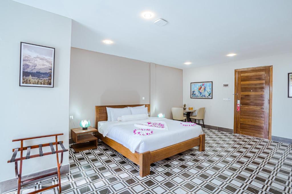 a bedroom with a large bed and a table at CALAO Kep Residence Hotel in Kep