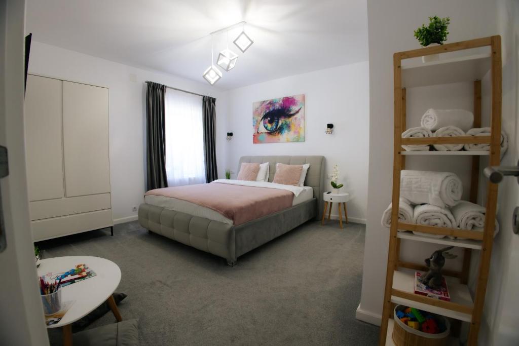 a bedroom with a bed and a shelf with towels at RR House Apartments in Râşnov