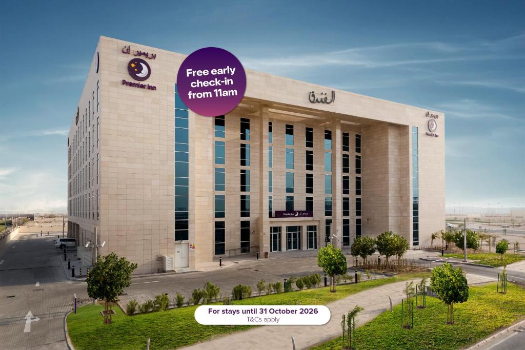 a large building with a sign on top of it at Premier Inn Doha Education City in Doha
