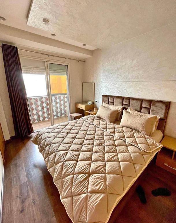 a bedroom with a large bed in a room at Slt hola bonjour marchica in Nador