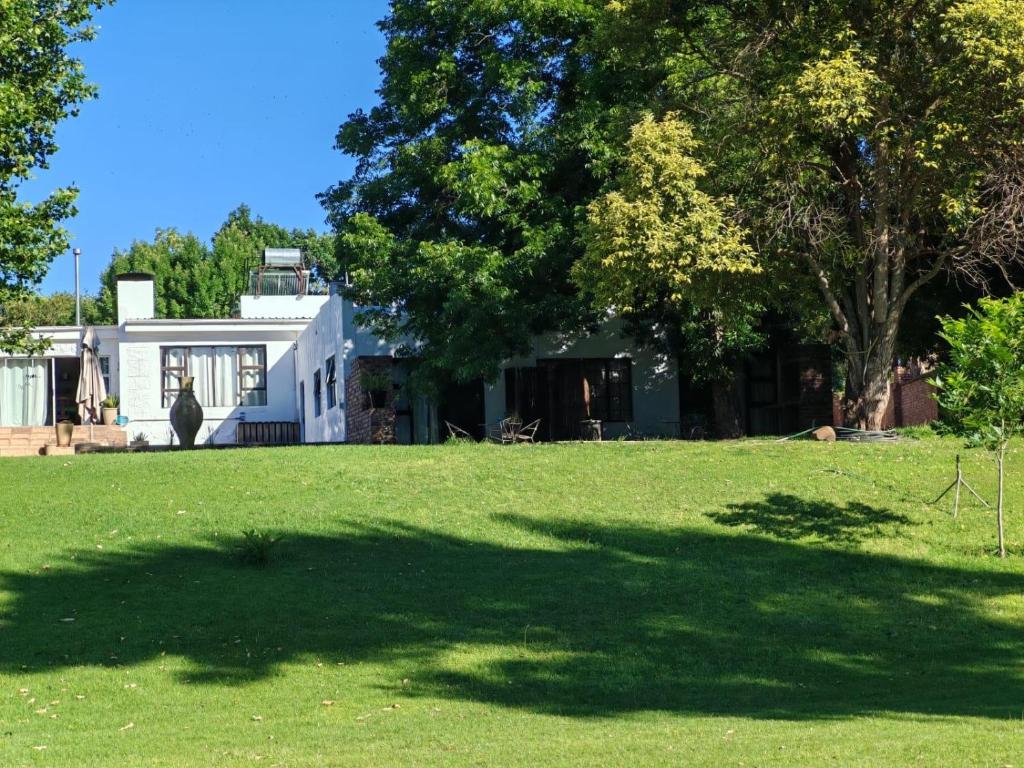 a house with a large shadow on the grass at ASAMé @ Oppi-Rivier in Christiana