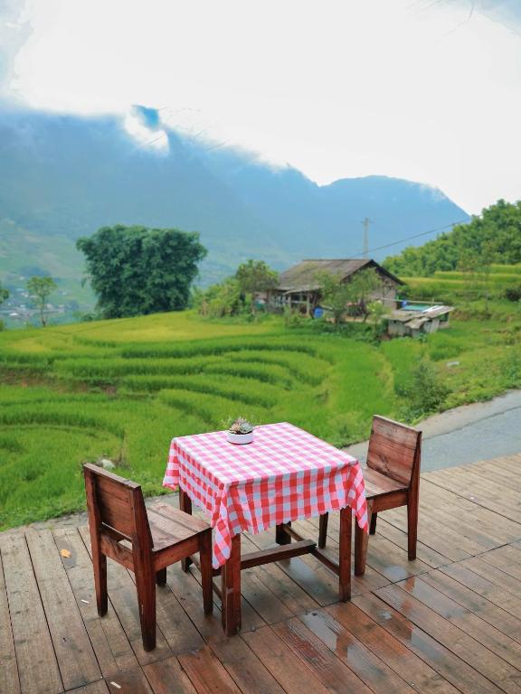 a table and two chairs sitting on a wooden deck at Ap Retreat - Ta Van's Heel in Sapa
