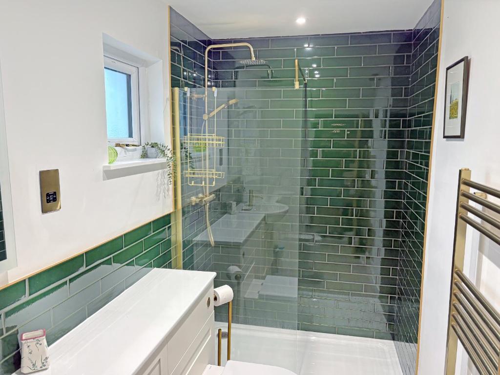 a bathroom with a green tiled shower at Hollinhaven in Blackwaterfoot