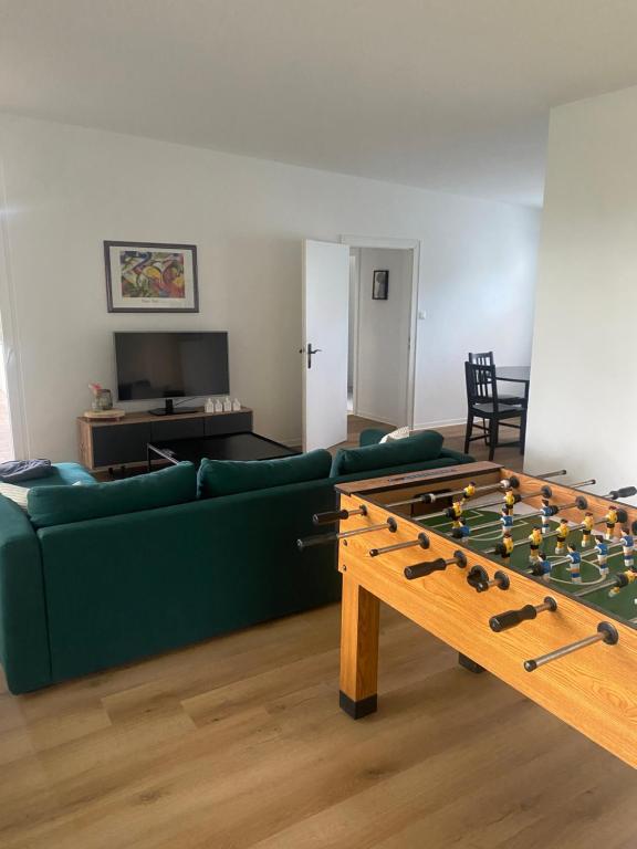 a living room with a green couch and a foos ball at Wohnung nah der Weser Monteurenwohnung Ferienwohnung in Hoya