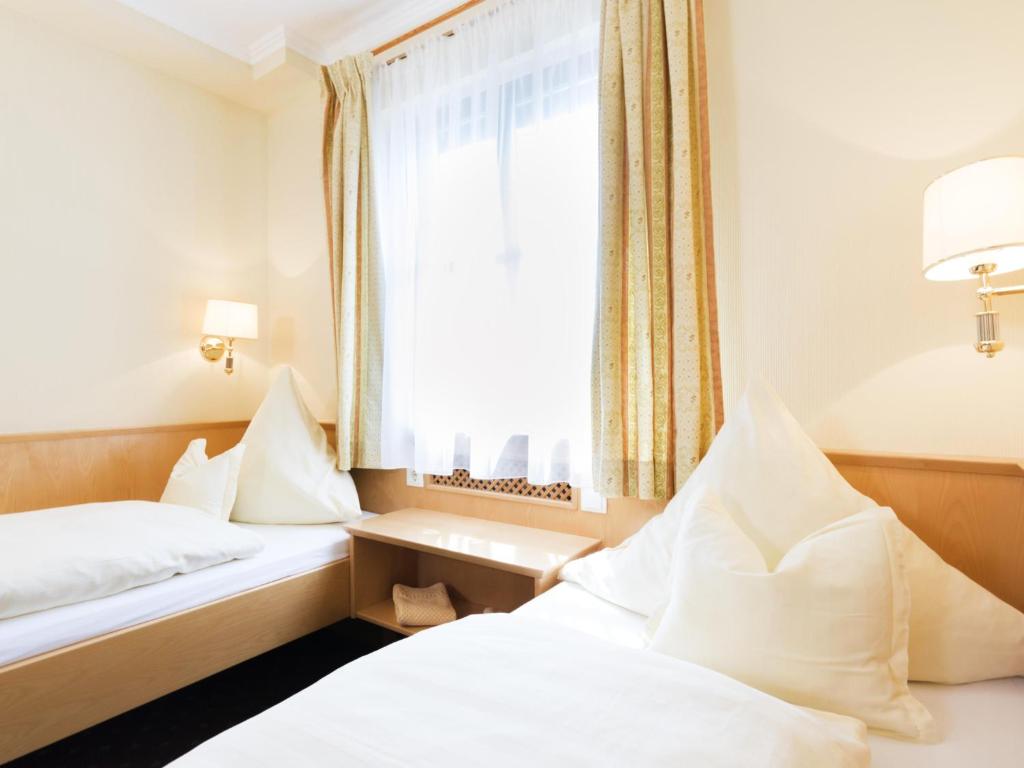 - 2 lits dans une chambre d'hôtel avec fenêtre dans l'établissement Gasthaus Glaser, à Bad Füssing