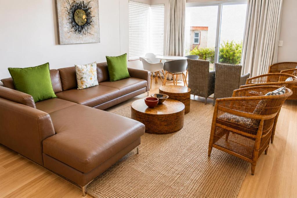 a living room with a brown couch and chairs at Jetty Seaview Apartment in Swakopmund