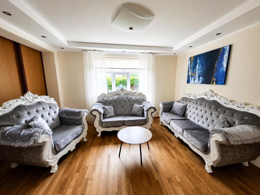 a living room with two couches and a table at Cozy Garden Villa in Ventspils