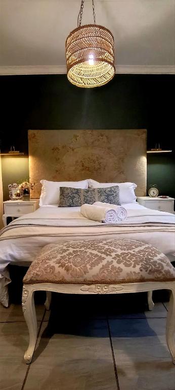 a bedroom with a large bed and a chandelier at Net 'n Bed in Middelburg