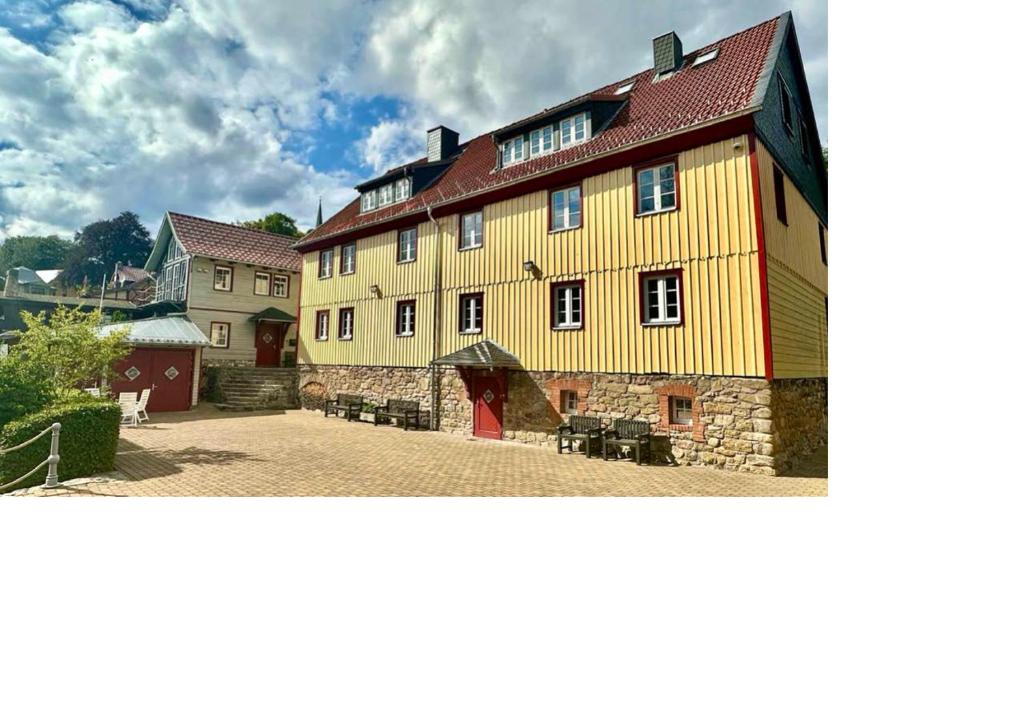 a large yellow building with a red roof at Alte Faktorei Schierke in Schierke