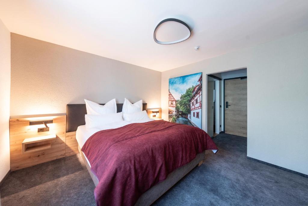 a bedroom with a large bed with a red blanket at Krone 1516 in Elchingen