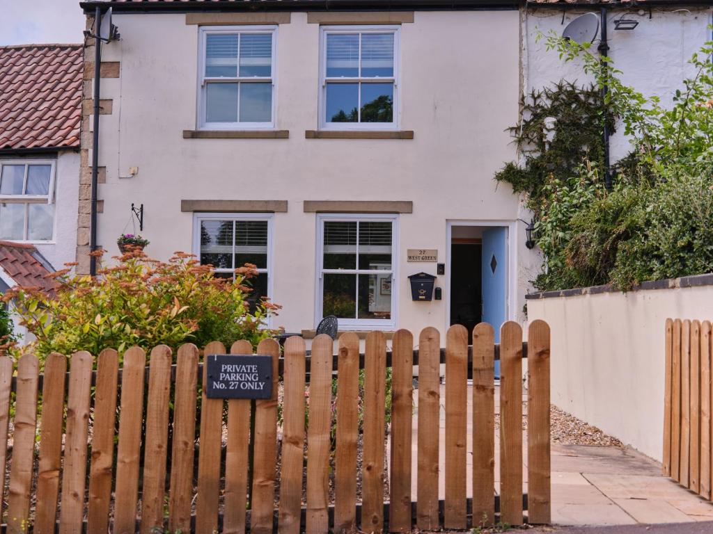 a wooden fence in front of a white house at 27 West Green in Newton Aycliffe