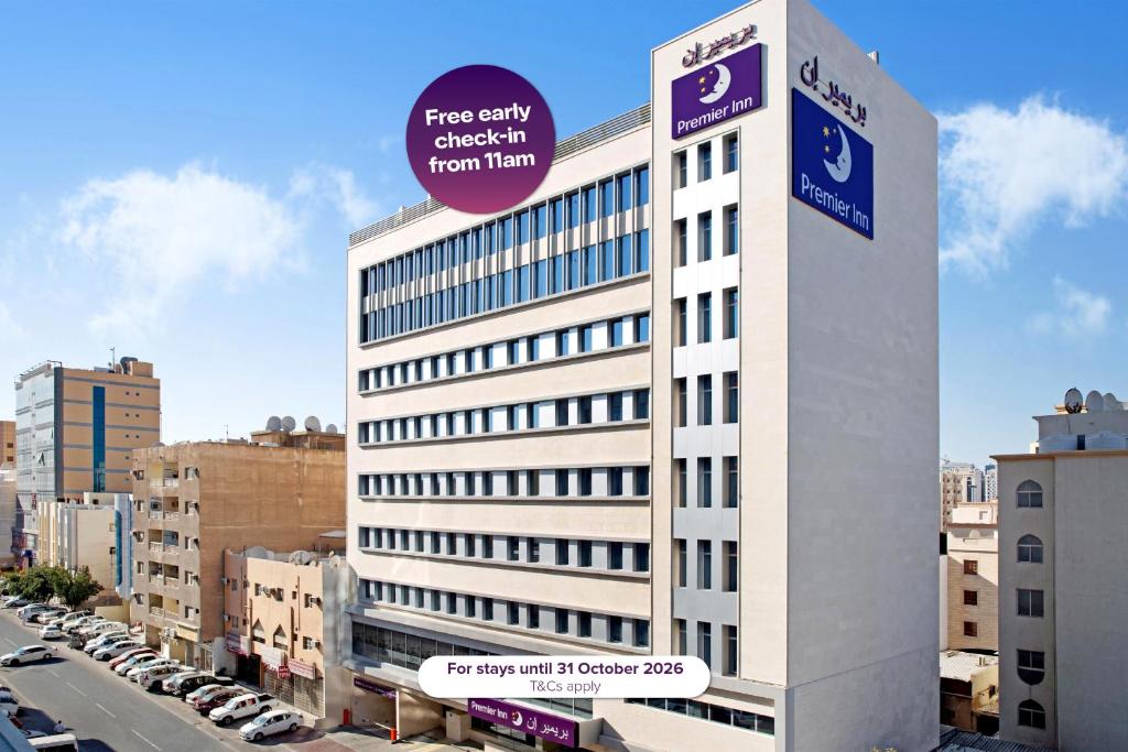 a white building with a sign on top of it at Premier Inn Doha Airport in Doha