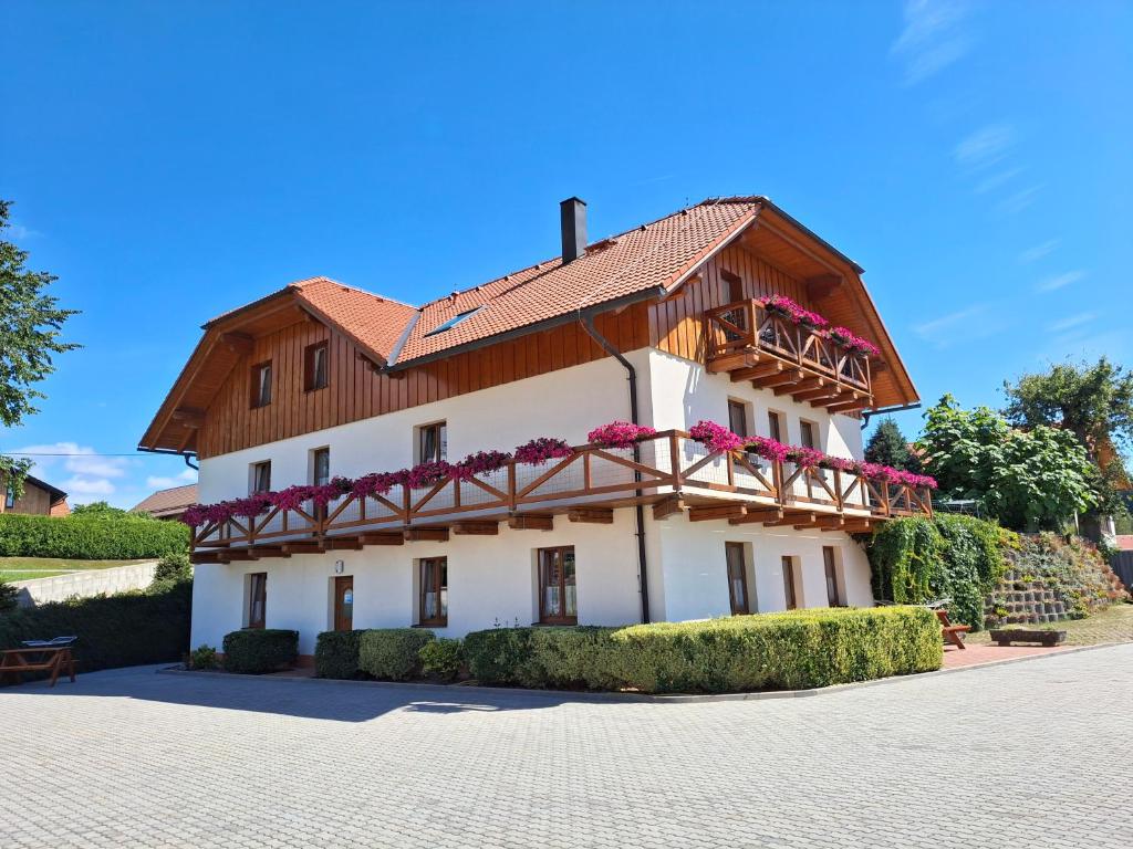 a white building with a wooden roof at Apartmány U Srdce Vltavy in Horní Planá