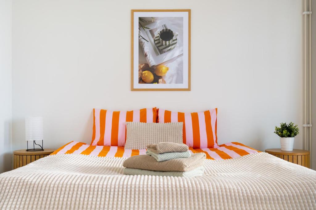 a bedroom with a bed with an orange and white blanket at Central Studio 33m2 Sauna Wifi Parkkipaikka in Kuusamo