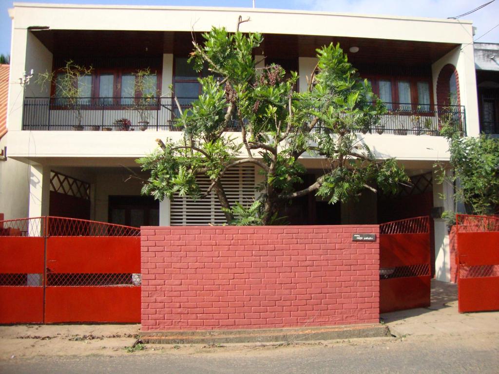 una pared de ladrillo rojo frente a una casa en Blue Waters, en Matara