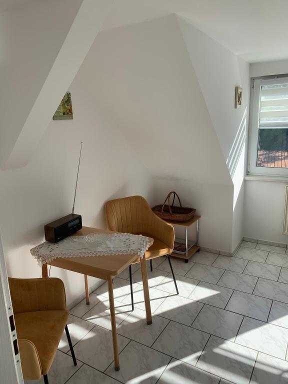 a table and chairs in a room with a staircase at Ferienwohnung Geiseltalsee Frankleben in Frankleben