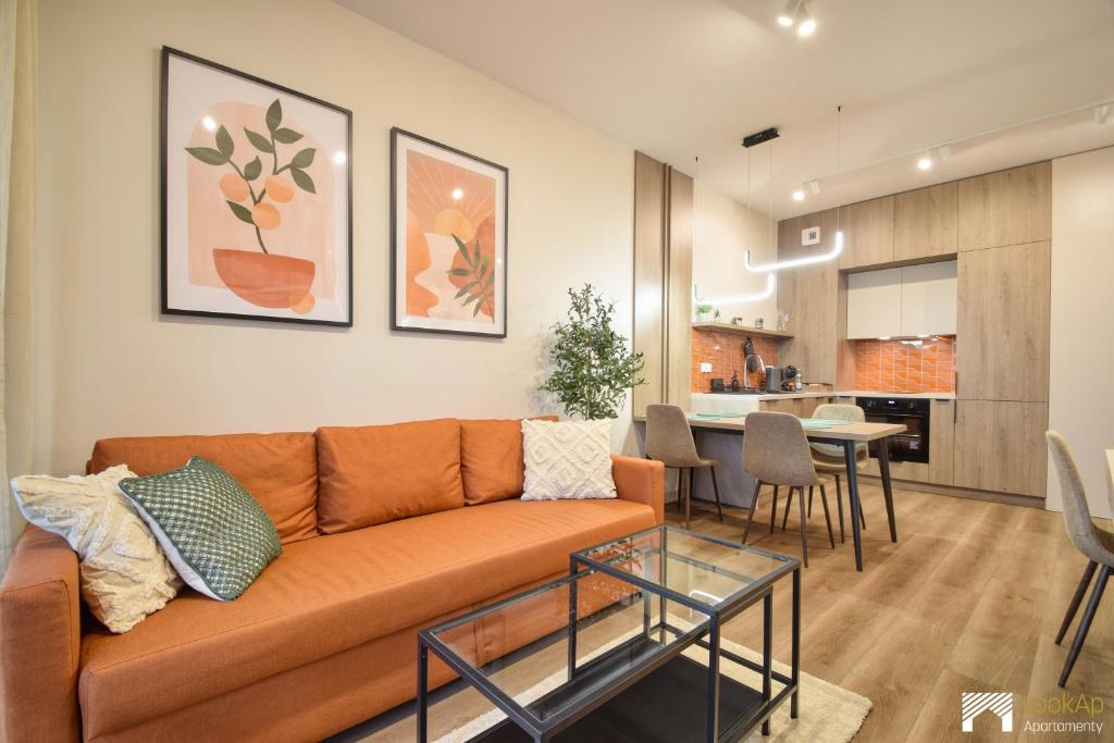 a living room with a couch and a dining room at Cavallia Garden by LookAp - parking w garażu, ogródek in Poznań