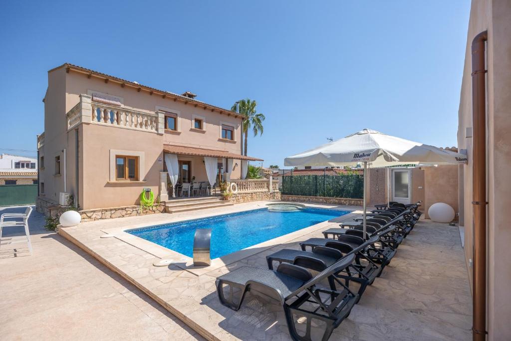 a villa with a swimming pool and a house at Los tres soles in Portocolom