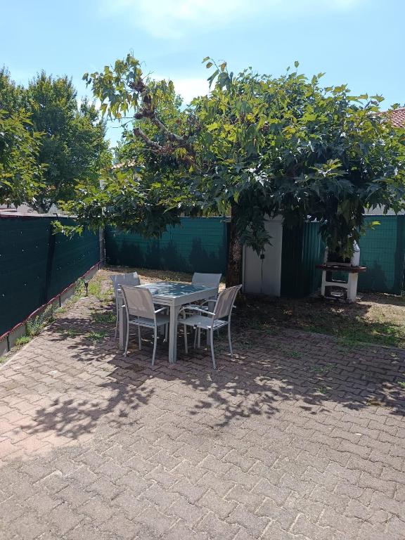a table and chairs sitting under a tree at MAISON BISCARROSSE LAC 6 pers in Biscarrosse