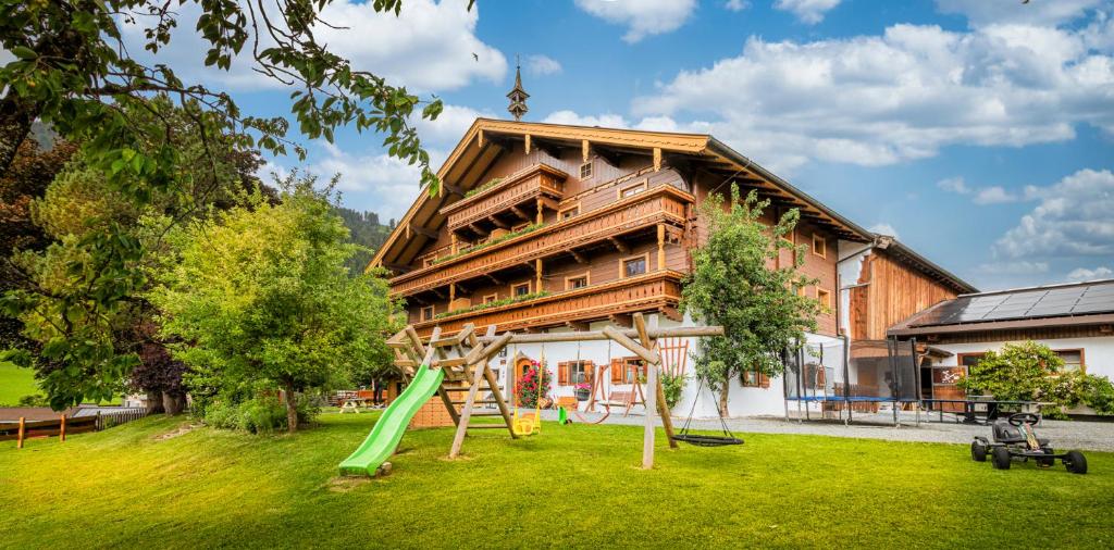 a house with a playground in front of it at Vorderkasbichlhof in Saalfelden am Steinernen Meer