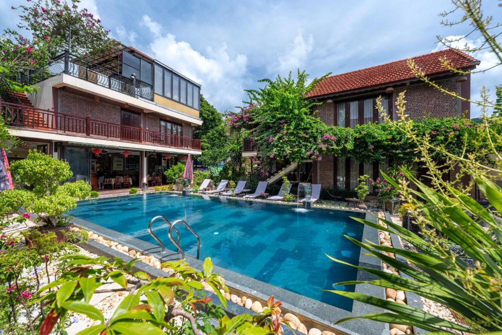 a swimming pool in front of a building at Tam Coc Ngoc Linh Bungalow Ninh Bình in Ninh Binh
