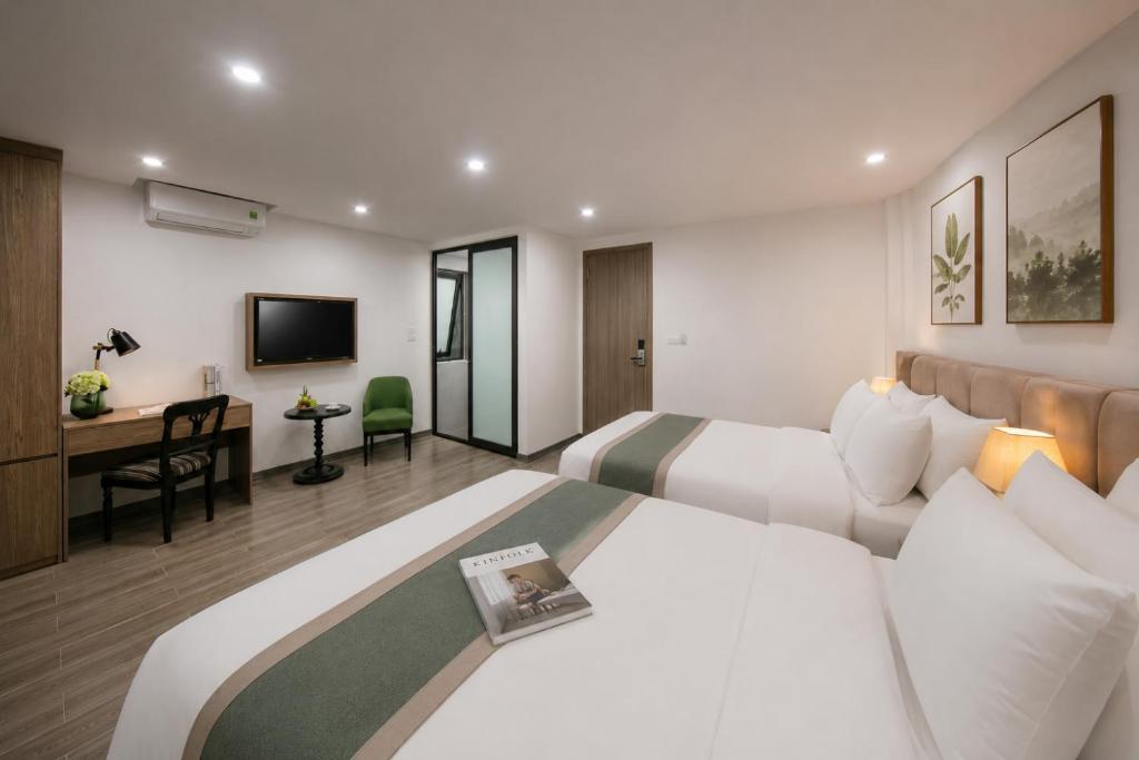 a hotel room with a bed and a desk at Emissary Corner Hanoi Hotel & Spa in Hanoi