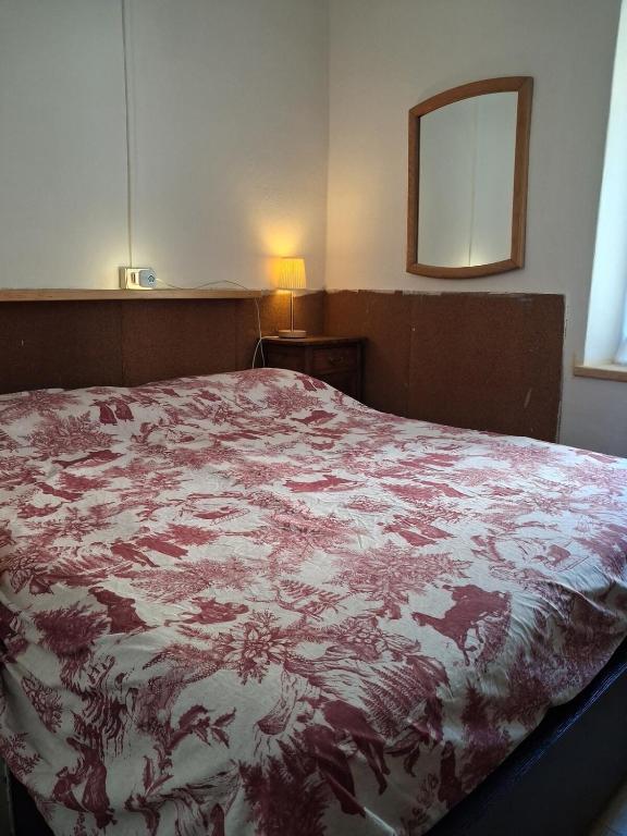 a bedroom with a bed with a red and white blanket at Cà Gianarín Authentic Dolomites Escape in Bocenago