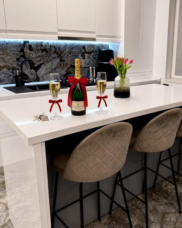 a white kitchen counter with two glasses of wine at Adinna Residence in Giroc
