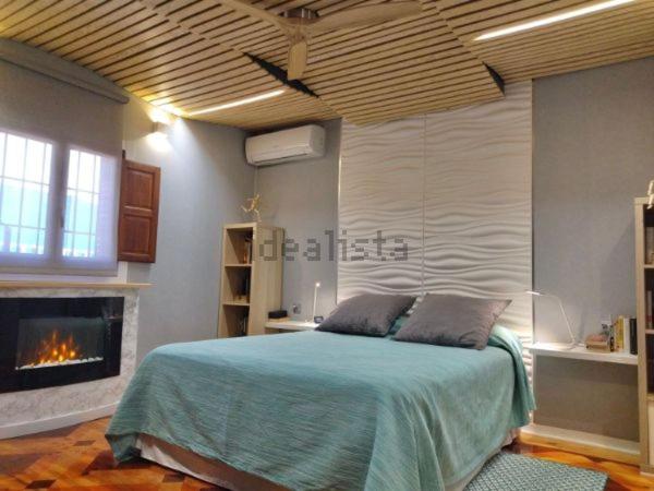 a bedroom with a bed and a fireplace at Chalet en Costacabana in Costacabana
