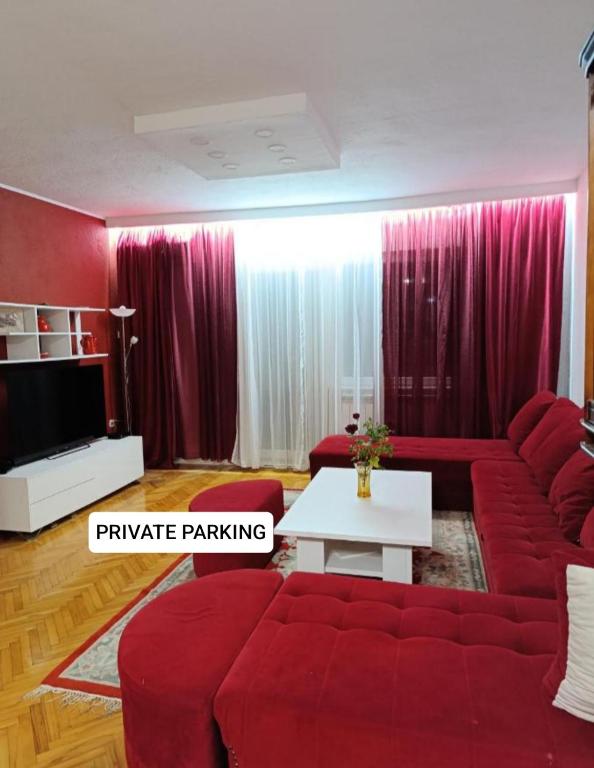 a living room with a red couch and a table at Apartment Tarik in Sarajevo
