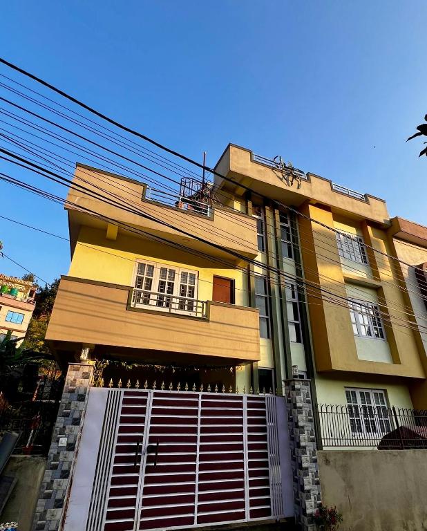 a tall yellow building with a gate in front of it at Sumitra Niwas-Home Away from Home in Bālāju