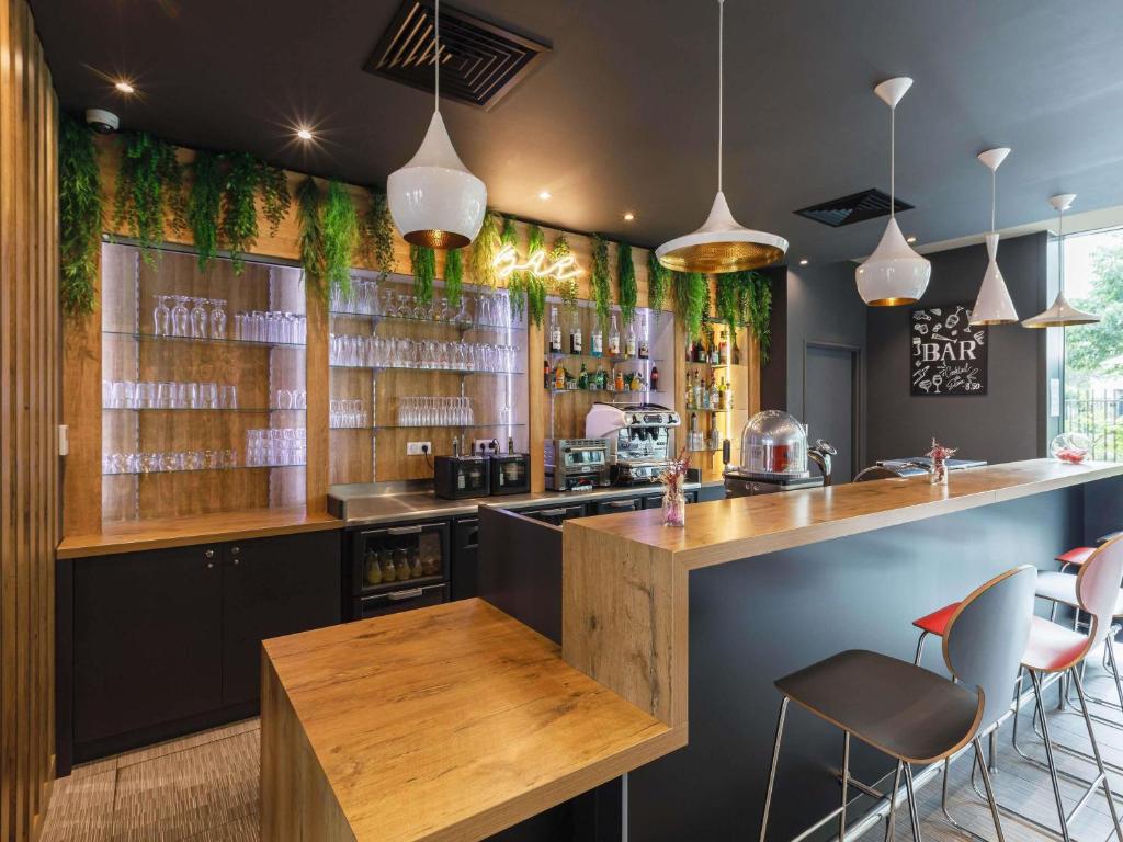a bar with a counter and chairs in a room at ibis Lyon Carre De Soie in Vaulx-en-Velin