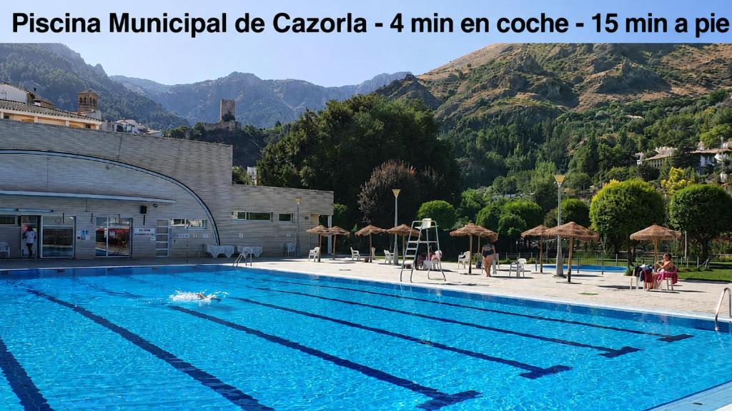 a large swimming pool with mountains in the background at Casa Chica in Cazorla