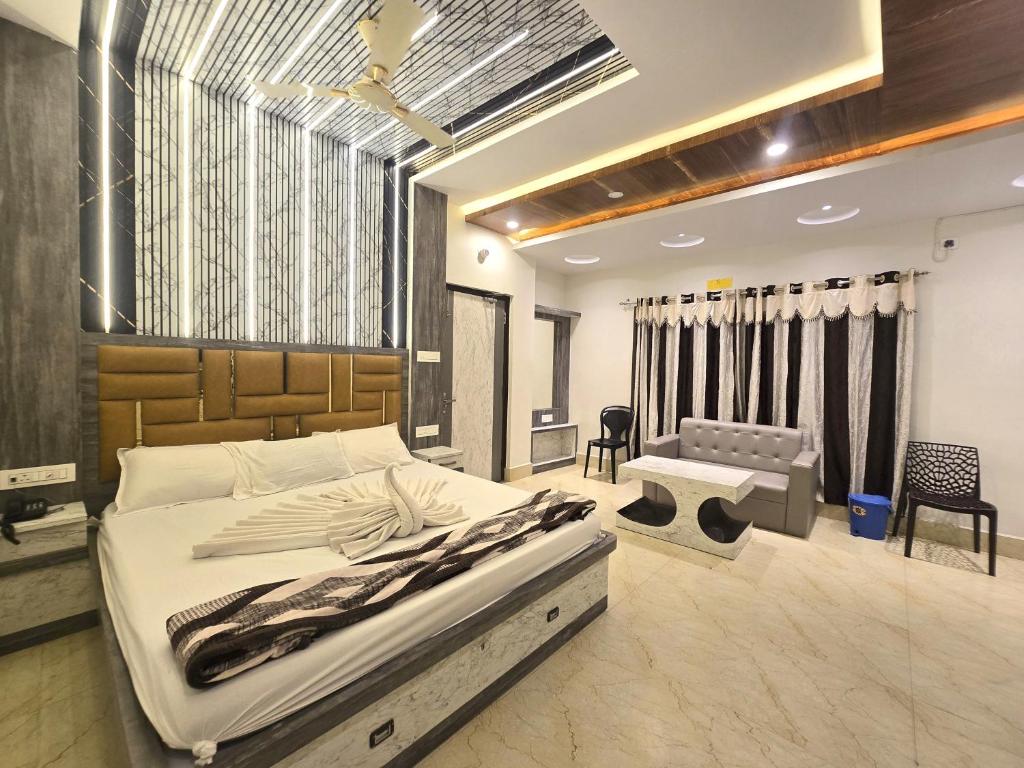 a bedroom with a large bed and a couch at Lokenath Resort in Tarapith