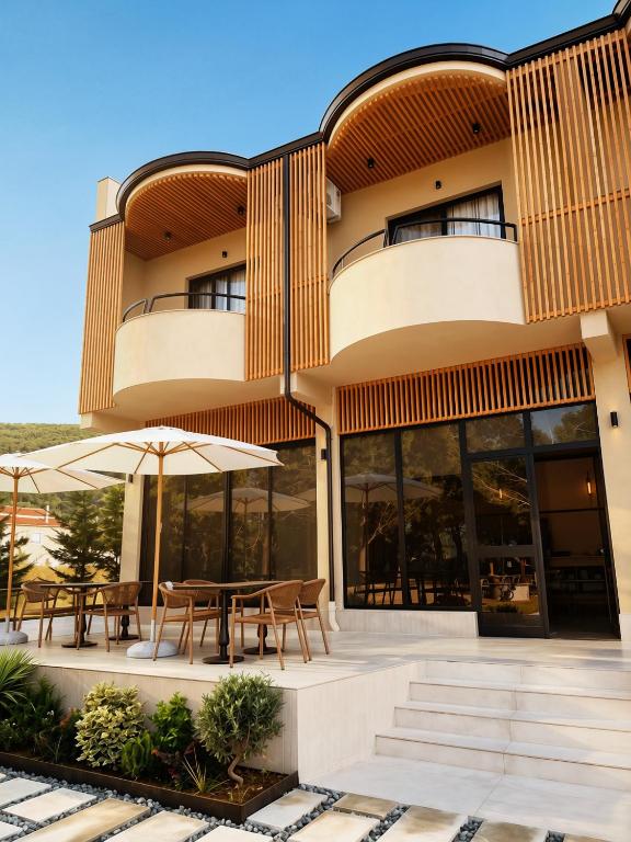 a building with tables and umbrellas in front of it at Azel Boutique Hotel in Draç