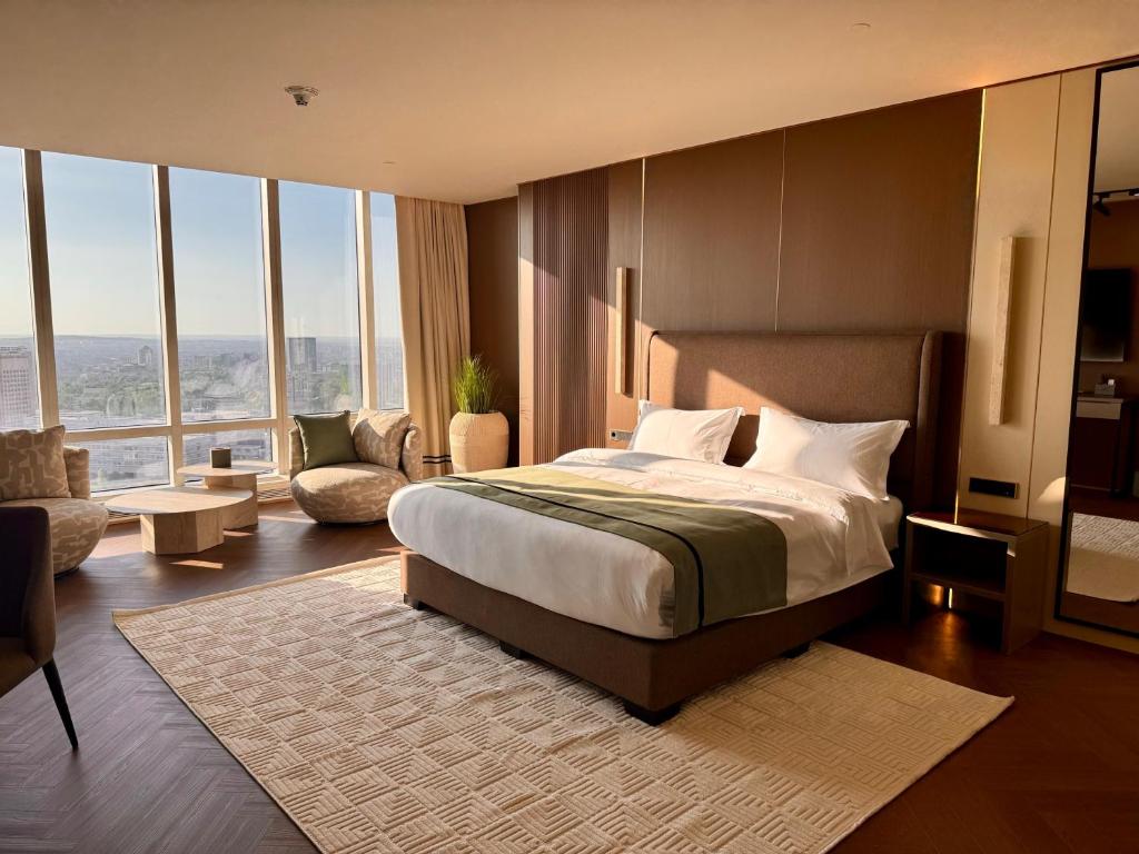 a bedroom with a bed and a living room at Boutique Hotel 19D in Almaty