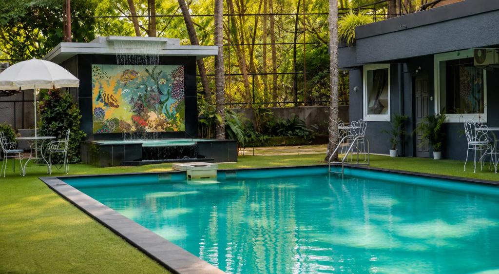 a swimming pool in a yard with a fountain at Magnum Resorts Candolim in Candolim