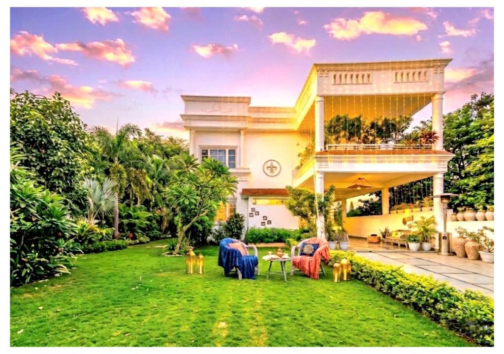 a house with a yard with chairs and tables at Giovanni Suites in Bhopal