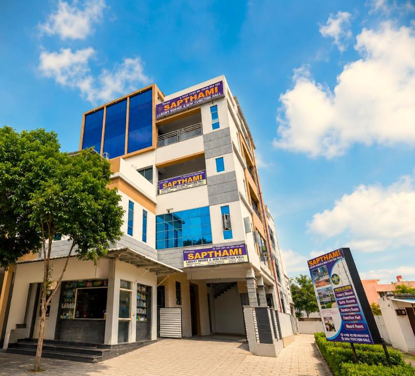 a building with a sign in front of it at Sapthami Luxury Rooms in Guntūr