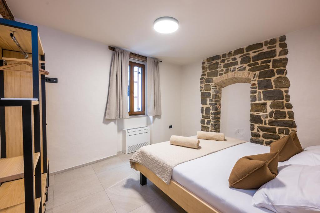 a bedroom with a bed and a stone wall at Lasa Pur Dir in Piran