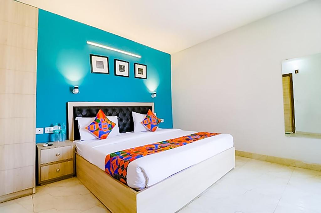 a bedroom with a large bed with a blue wall at Hotel Goldwind stay - Near Karkardooma Metro in New Delhi