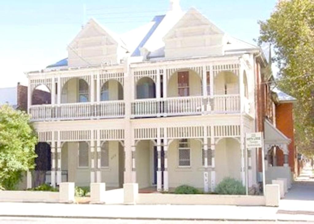 a large white house with a balcony on a street at Northlodge Central City Apartments in Perth