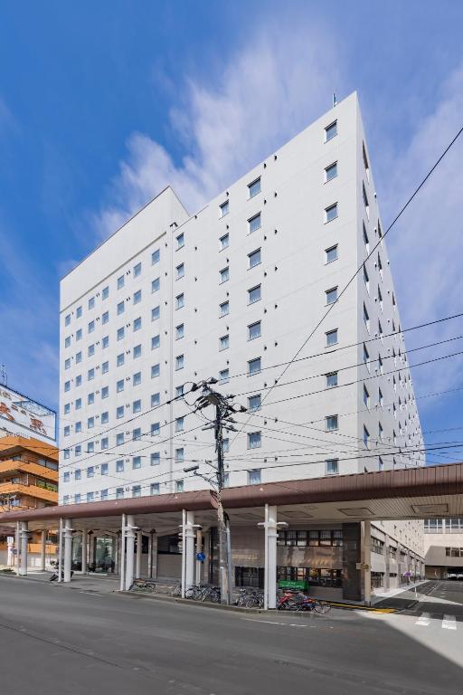 a large white building on the side of a street at Hotel New Green Plaza in Nagaoka
