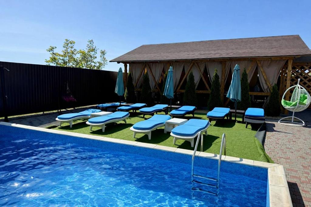 a swimming pool with chairs and umbrellas next to a pool at Qzone 2 in Chornomorsk