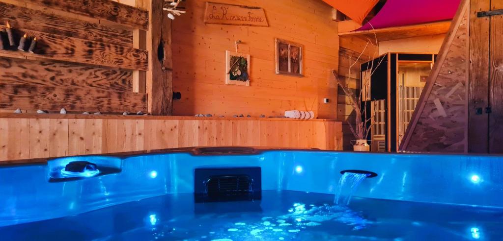 a blue tub in a room with a fireplace at Maison D'hôtes et Spa La Boucotte in Vellerot-lès-Vercel